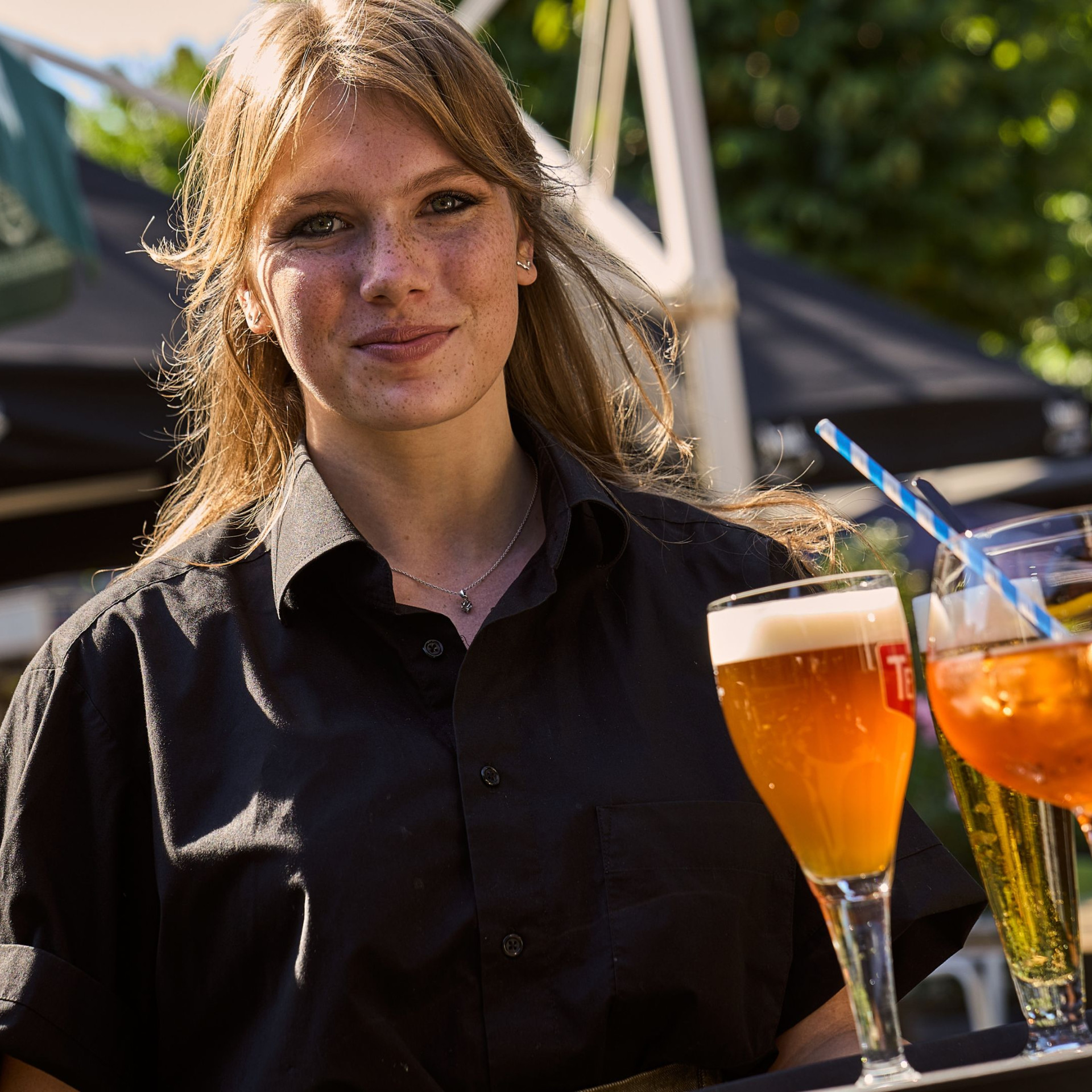 Serveerster met drankjes op het terras.